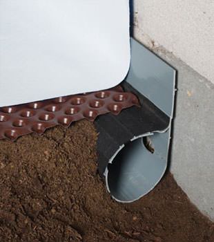 Closeup of a crawl space drainage system installed in 